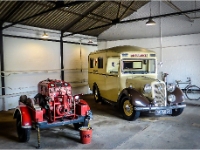Inside A Garage.  Fire fighting equipment and an ambulance of the period.