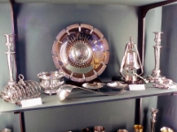 The Coat Of Arms On A Silver Bowl.  All the items in this display are solid silverand were made about 1860. The bowl in the centre has the coat of arms on a raised central portion.