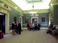 The Reception Room And Drawing Room.  Members, wives, and partners, taking coffee in the drawing room and reception room. The walls are decorated with portraits of past Master Cutlers. There is also a part finished painting of Prince Philip as a young man.